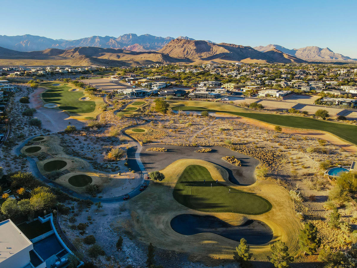 A golf course with many holes and mountains in the background.